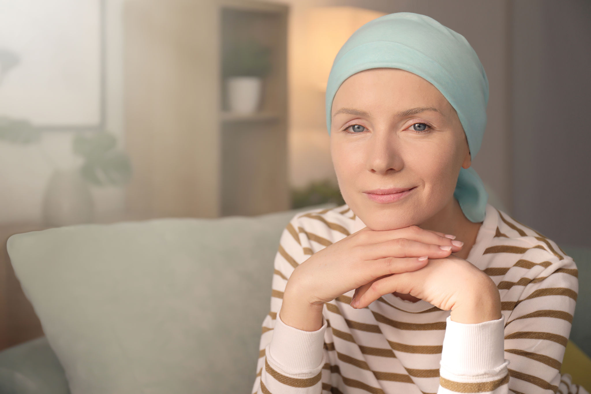 Young woman with cancer in headscarf indoors